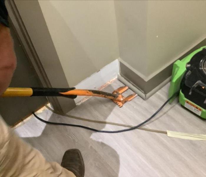 A SERVPRO professional removing baseboard and trim in a Madison County property